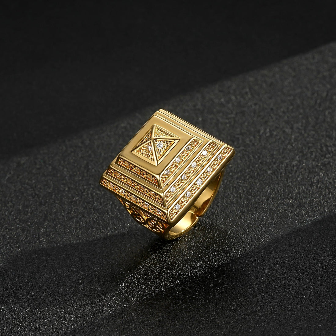 Gold pyramid ring with a 25mm top view on a reflective surface